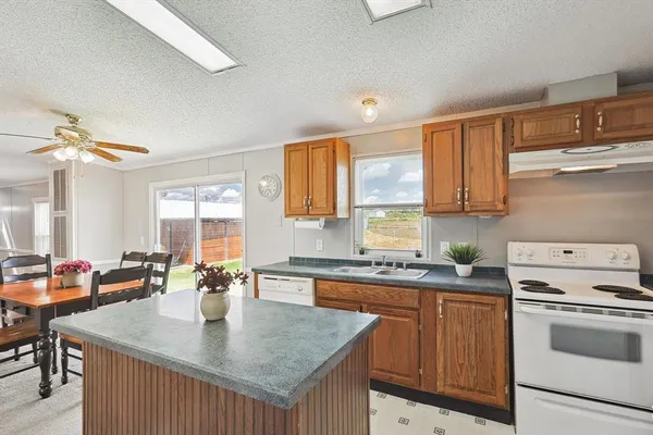a kitchen with a stove a sink a refrigerator and cabinets