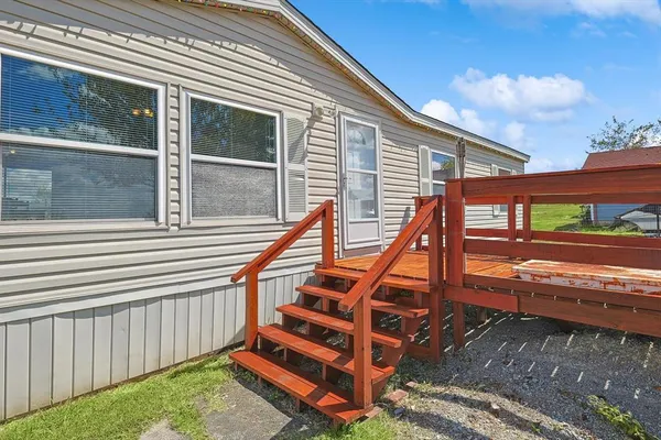 a view of backyard with deck and wooden stairs