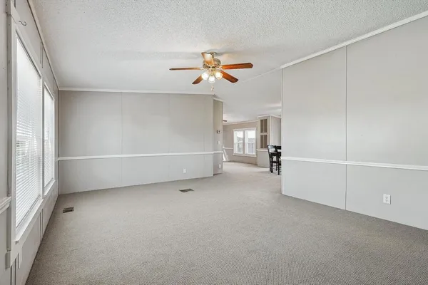a view of a livingroom with a ceiling fan and window