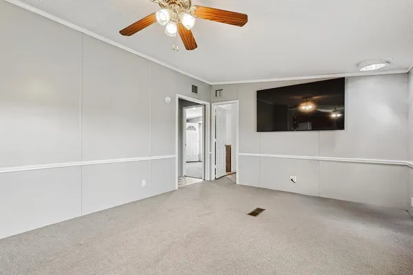 an empty room with windows and fan