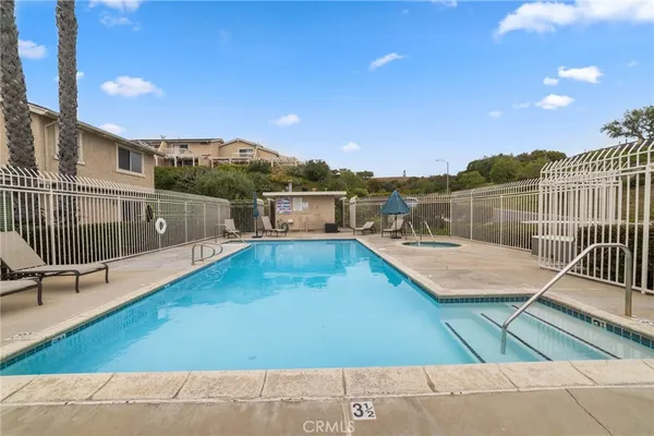 a view of a swimming pool with a lounge chair and floor to ceiling window
