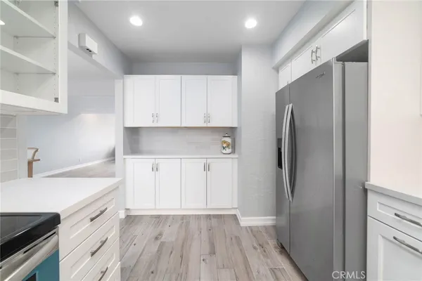a kitchen with a refrigerator sink and cabinets