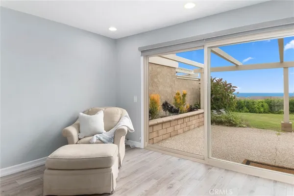 a living room with a floor to ceiling window and a wooden floor