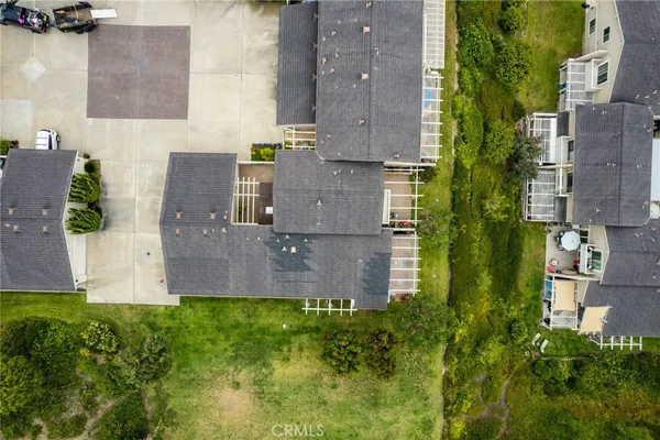 an aerial view of residential houses with outdoor space and parking