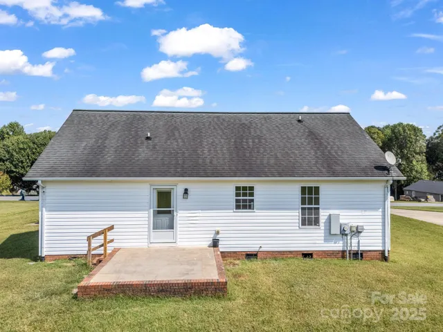 a backyard of a house with table and chairs