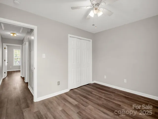 a view of a room with wooden floor and a ceiling fan