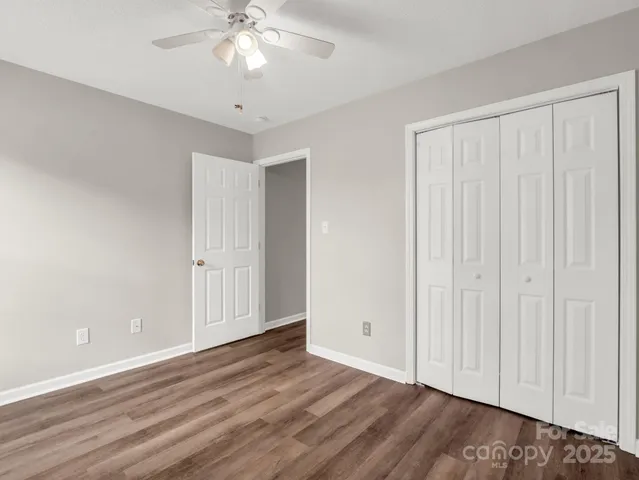 a view of a room with wooden floor and ceiling fan