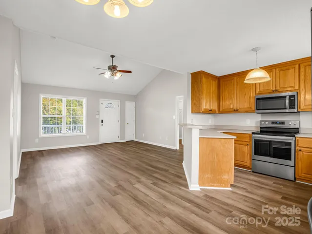 a kitchen with wooden floors and stainless steel appliances