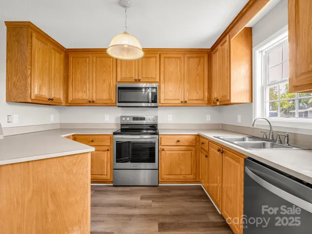a kitchen with stainless steel appliances granite countertop a sink a stove and a refrigerator