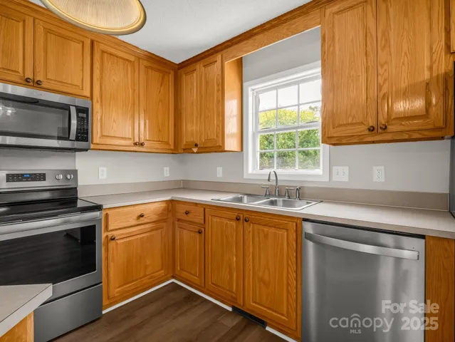 a kitchen with stainless steel appliances granite countertop wooden cabinets a sink and a stove