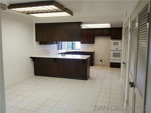 40 Green Turtle Road Coronado, CA 92118 - Photo 5 of 11 a kitchen with stainless steel appliances a stove a microwave and a refrigerator