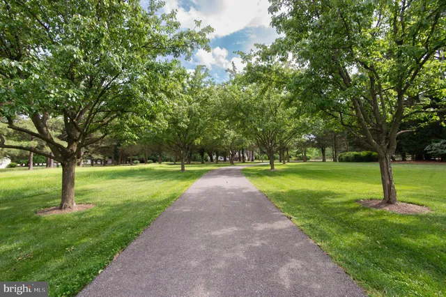 a front view of a house with a garden and trees