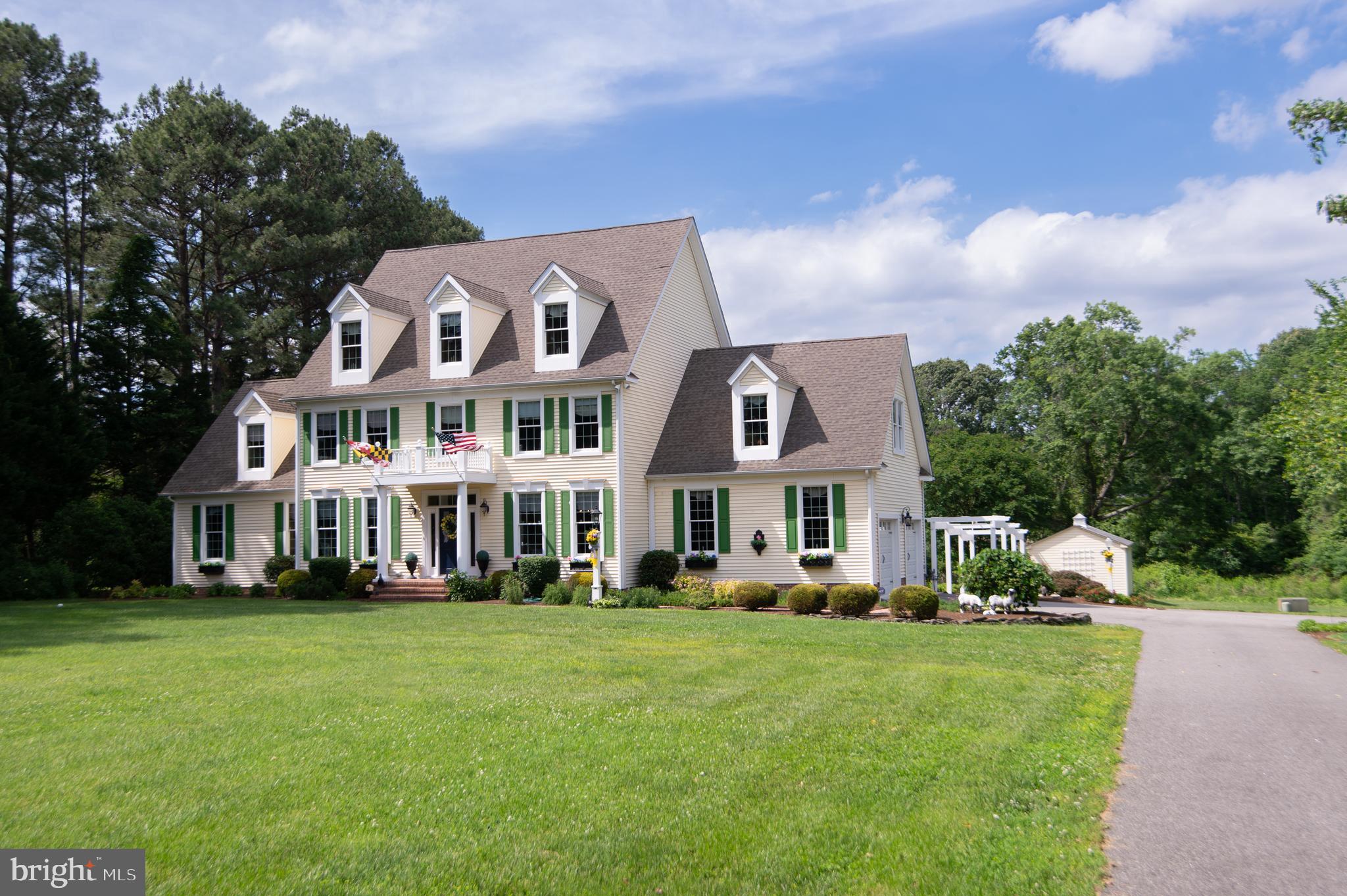 28028 Playtor Road Easton, MD 21601 - Photo 8 of 80 a front view of a house with a garden and trees