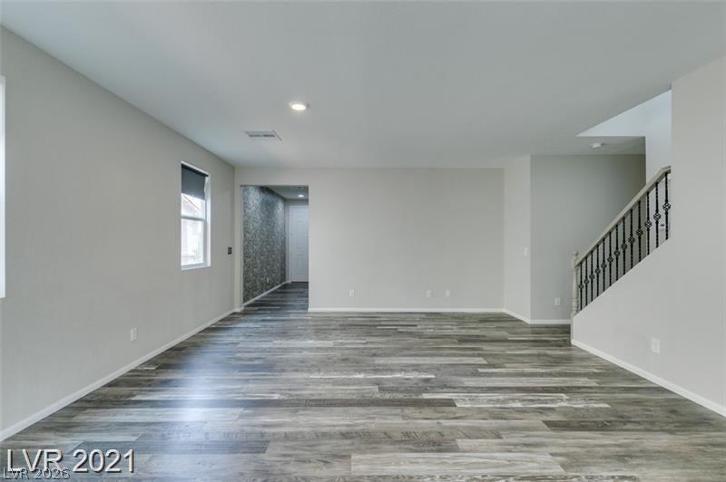 5475 Ordesa Valley Road Las Vegas, NV 89148 - Photo 29 of 35 Wood-look flooring stretches across this naturally illuminated living area, leading to a stately staircase.