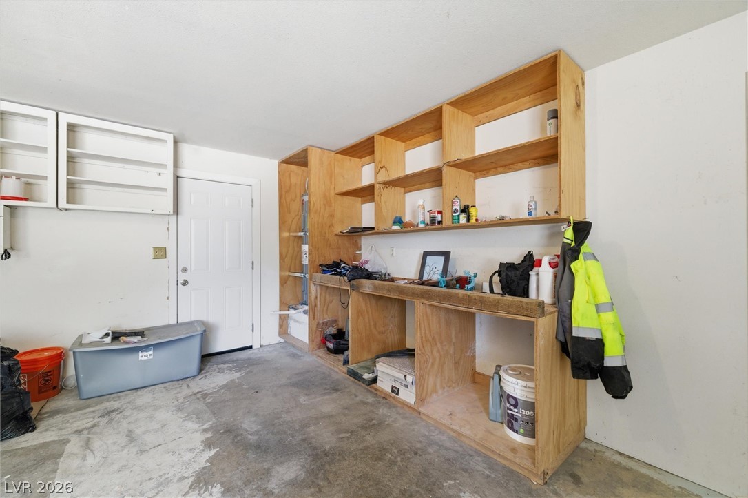 2780 West Simkins Road Pahrump, NV 89060 - Photo 22 of 40 Functional garage with built-in wooden shelving provides ample storage solutions.