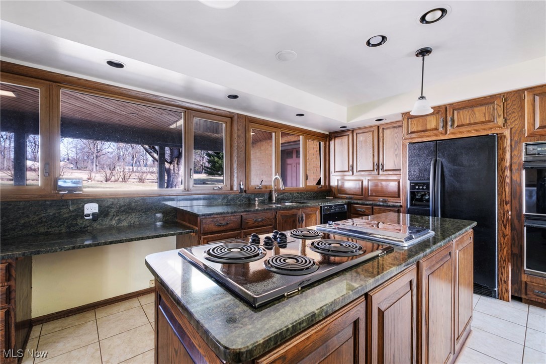 7059 Stewart Sharon Road Hubbard, OH 44425 - Photo 20 of 49 Kitchen featuring light tile patterned floors, a sink, electric stovetop, pendant lighting, and black refrigerator with ice dispenser