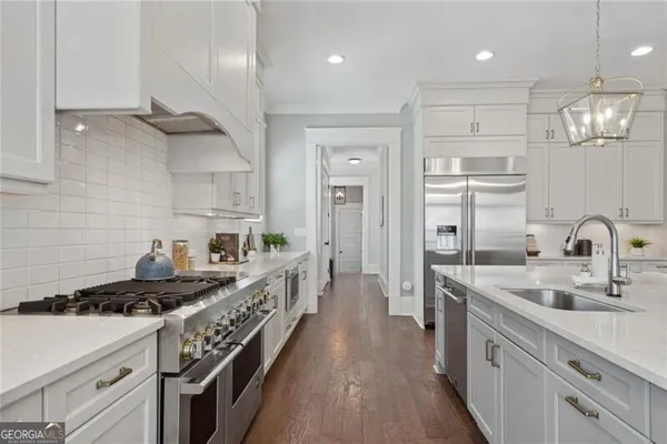 a kitchen with kitchen island a sink stove and refrigerator