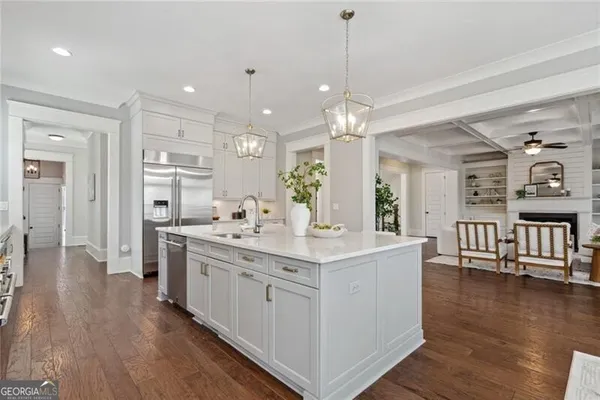 a large white kitchen with lots of counter space and refrigerator