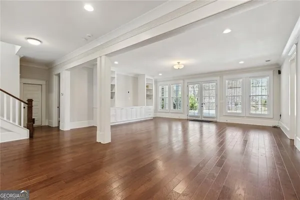a view of an empty room with wooden floor and a cabinet