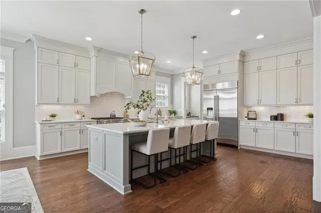 a large kitchen with kitchen island white cabinets and stainless steel appliances