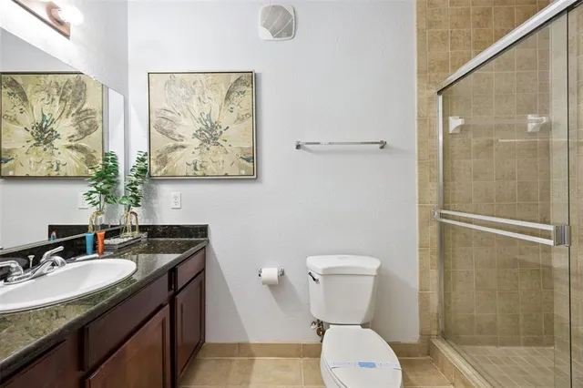 a bathroom with a granite countertop sink toilet and a mirror