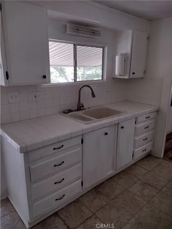 a kitchen with cabinets appliances and a window