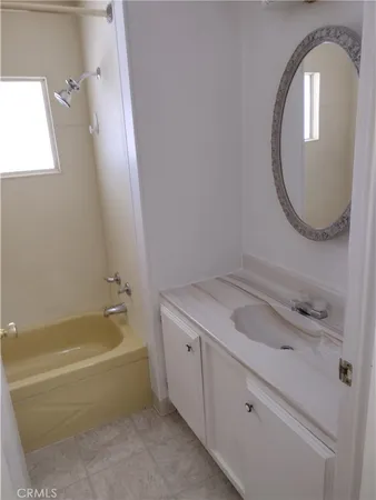 a bathroom with a tub sink and mirror