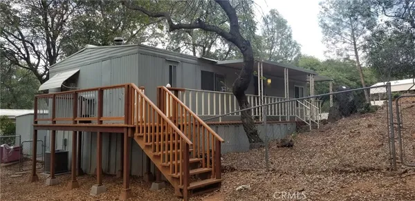 a view of a house with a yard and wooden deck