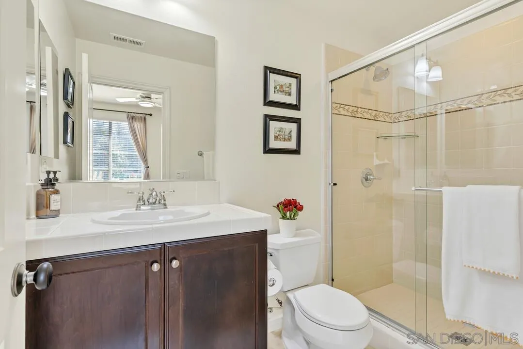 14622 Whispering Ridge Road San Diego, CA 92131 - Photo 13 of 75 a bathroom with a sink a toilet and shower