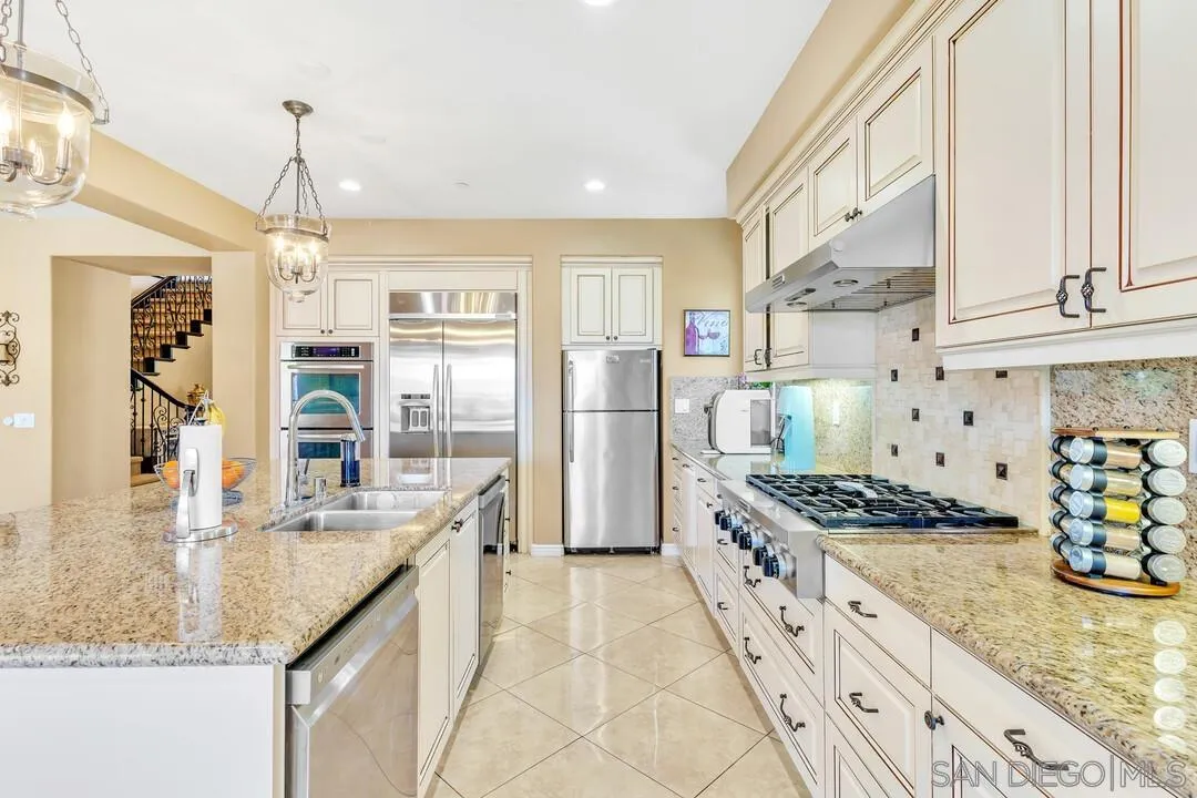 14622 Whispering Ridge Road San Diego, CA 92131 - Photo 17 of 75 a kitchen with stainless steel appliances granite countertop a stove and a refrigerator