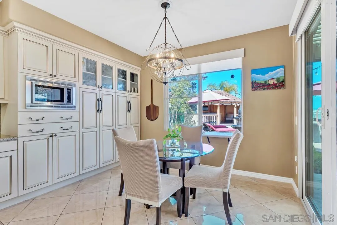 14622 Whispering Ridge Road San Diego, CA 92131 - Photo 19 of 75 a dining room with furniture a chandelier and window