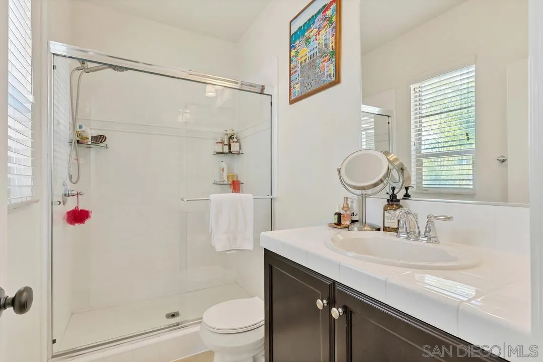 14622 Whispering Ridge Road San Diego, CA 92131 - Photo 47 of 75 a bathroom with a granite countertop sink a toilet and shower