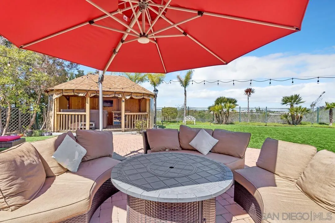 14622 Whispering Ridge Road San Diego, CA 92131 - Photo 62 of 75 a view of a patio with a table and chairs under an umbrella