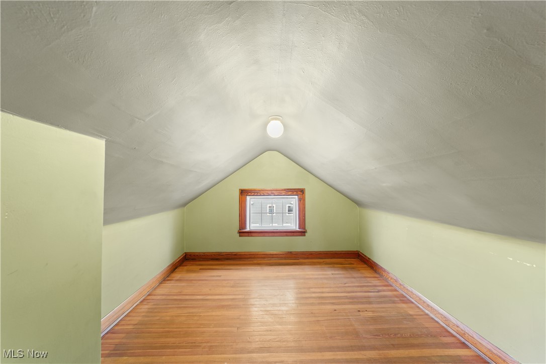 2891 Huntington Road Cleveland, OH 44120 - Photo 35 of 44 3rd floor bonus space Additional living space with light wood-style flooring, baseboards, vaulted ceiling, and a textured ceiling
