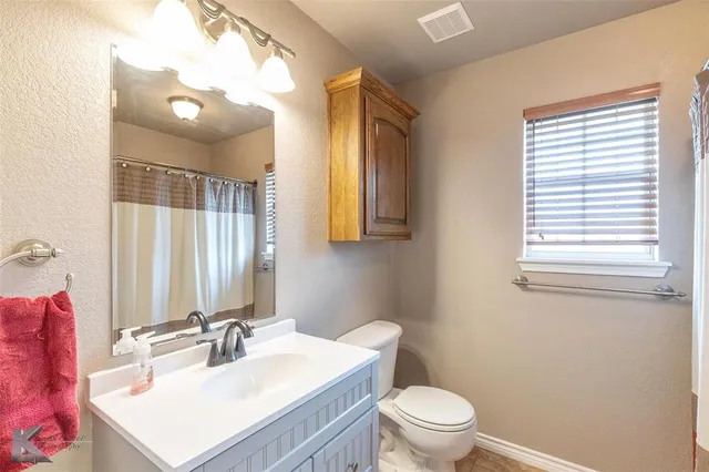 a bathroom with a sink vanity mirror and toilet