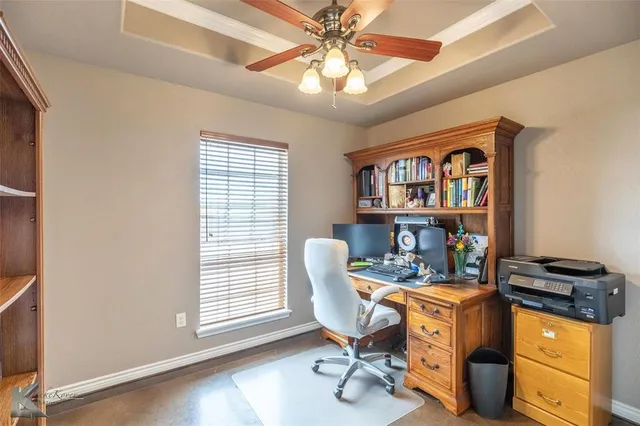a view of a workspace with furniture and a window
