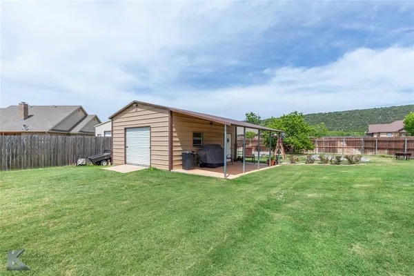 a view of a backyard with a garden and entertaining space