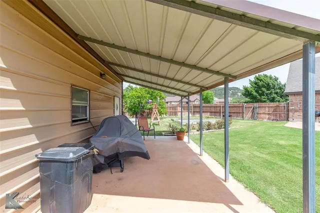 a view of a backyard with floor to ceiling window and wooden fence