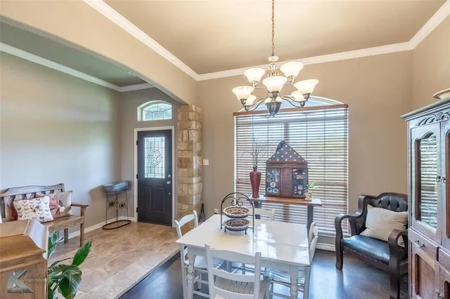 a view of a dining room with furniture a chandelier and wooden floor