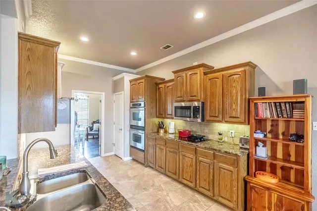 a kitchen with granite countertop a refrigerator and a sink