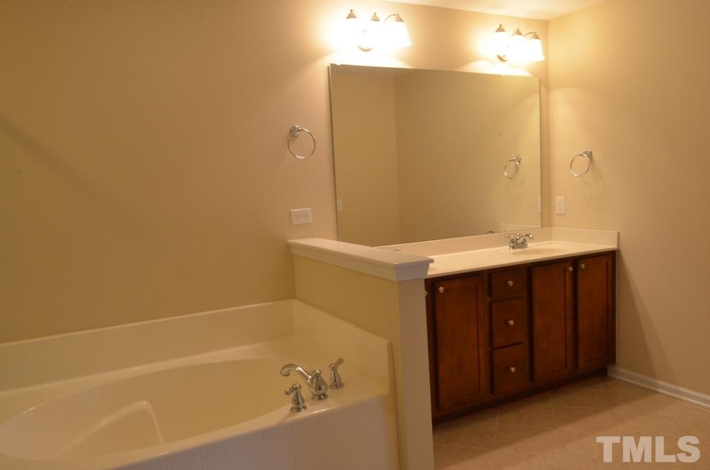 509 Dragby Lane Raleigh, NC 27603 - Photo 16 of 25 a bathroom with a tub sink and mirror