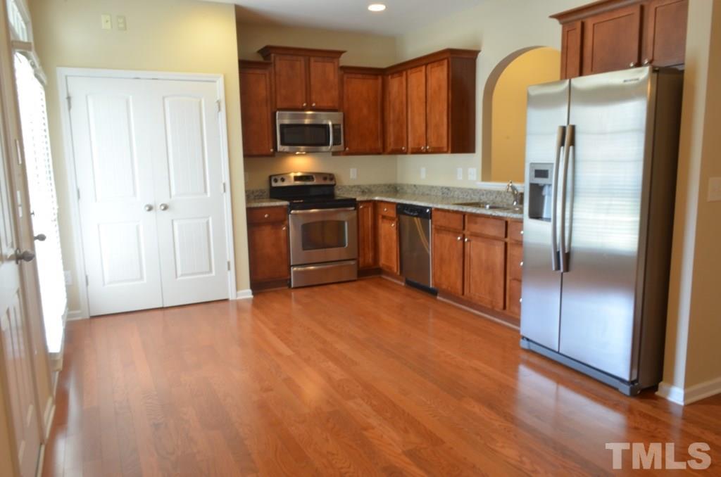 509 Dragby Lane Raleigh, NC 27603 - Photo 8 of 25 a kitchen with stainless steel appliances granite countertop a refrigerator and a stove top oven