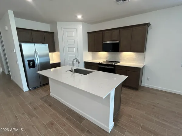 a kitchen with stainless steel appliances a stove a microwave a sink and a refrigerator