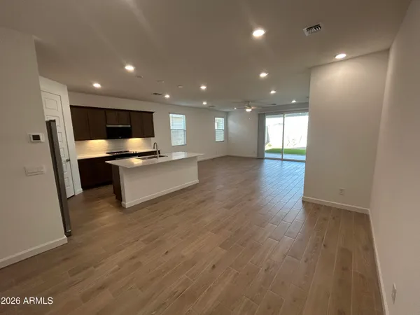 a view of kitchen with kitchen island wooden floor center island and stainless steel appliances