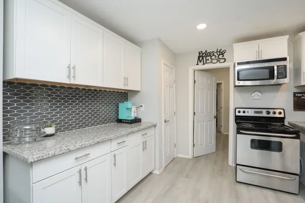 a kitchen with a sink dishwasher a stove and a refrigerator with wooden floor