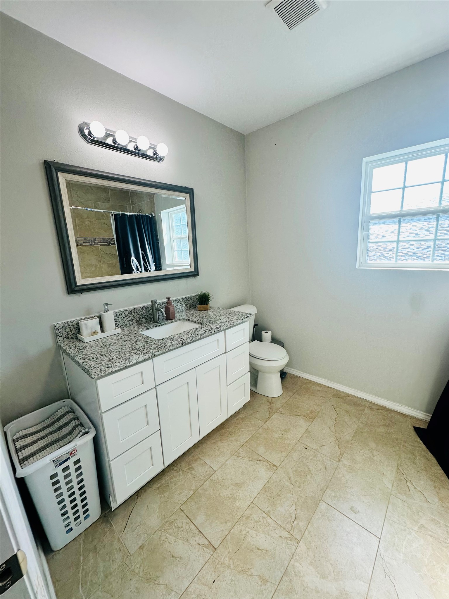 323 North Outlar Street Wharton, TX 77488 - Photo 16 of 25 a bathroom with a toilet sink and mirror