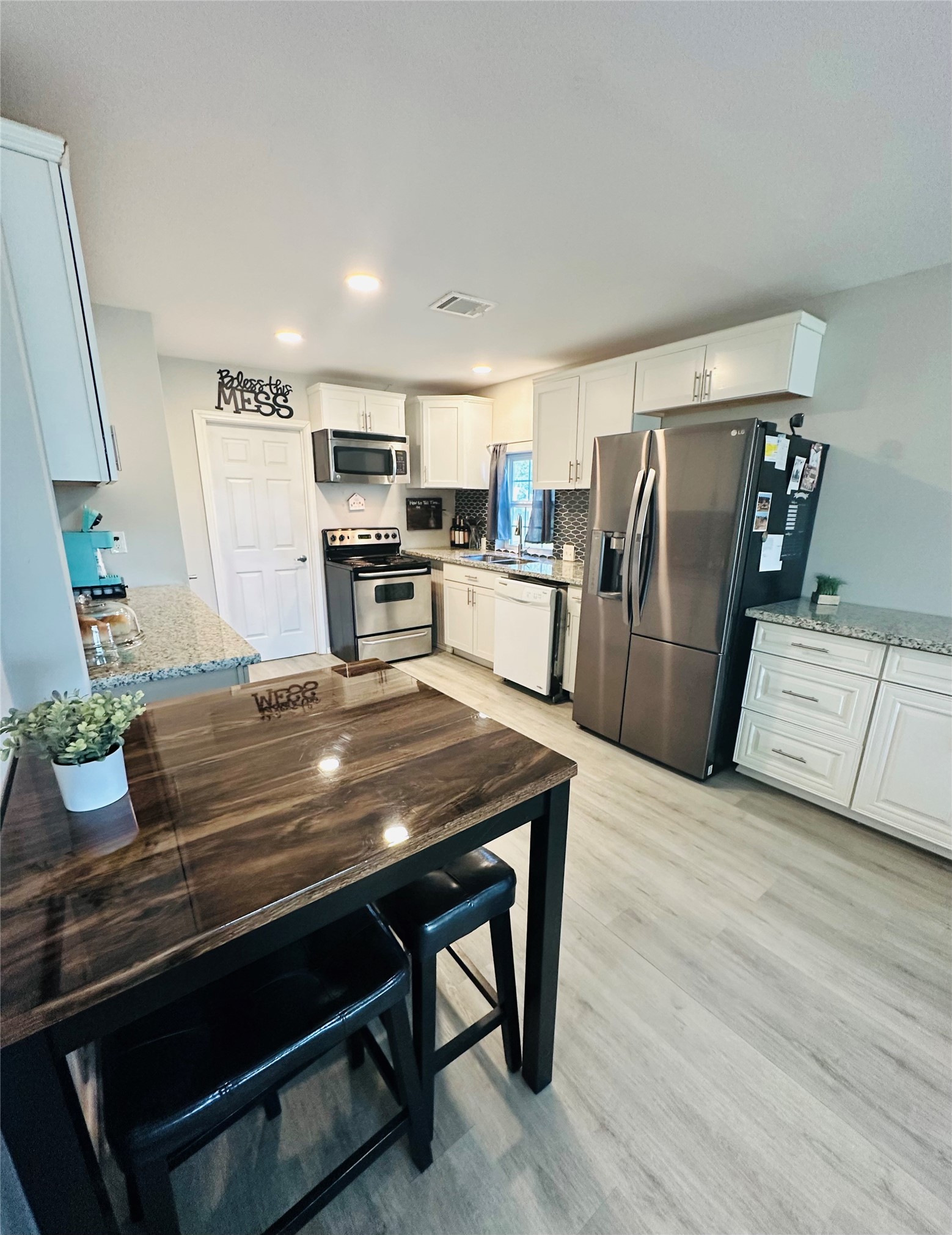 323 North Outlar Street Wharton, TX 77488 - Photo 5 of 25 a view of kitchen with refrigerator stove and wooden floor