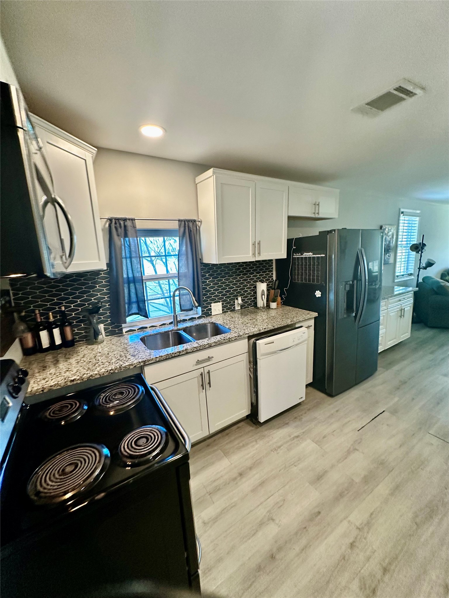 323 North Outlar Street Wharton, TX 77488 - Photo 7 of 25 a kitchen that has a sink cabinets counter space and stainless steel appliances