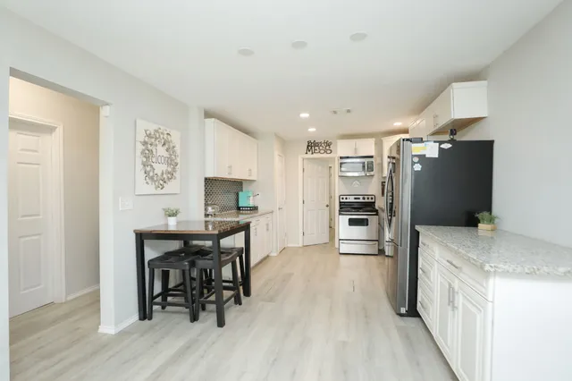 a kitchen with stainless steel appliances granite countertop a stove a sink and a refrigerator