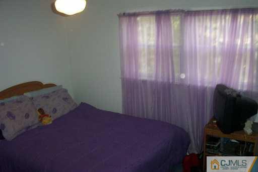 1257 Brookside Road Piscataway, NJ 08854 - Photo 5 of 8 a bedroom with a bed and a chair